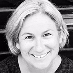 Black and White closeup headshot of me smiling. I am a white woman, my hair is short and gray.